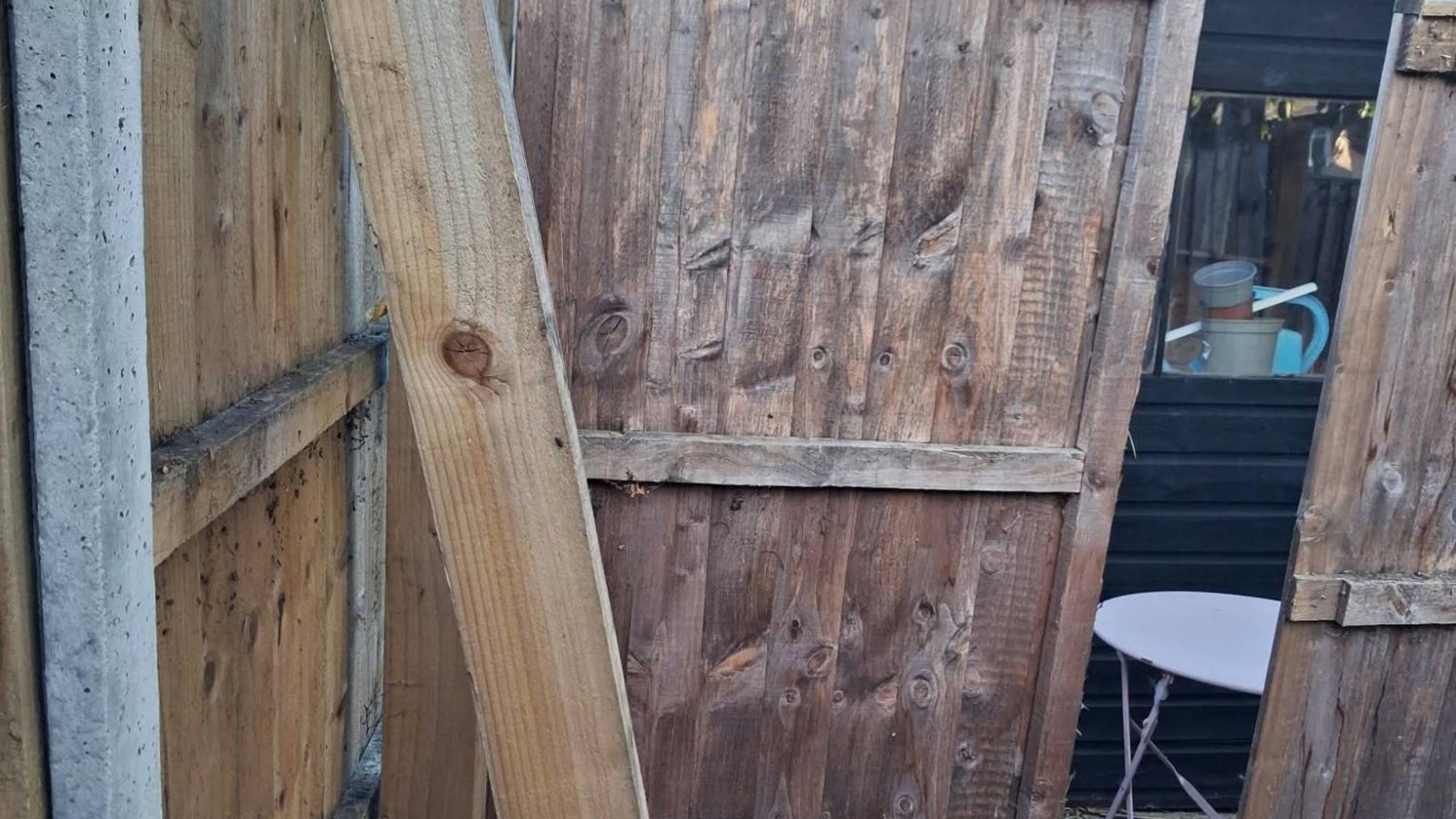 Before: a fence panel leaning out of line with a loose post propped against it
