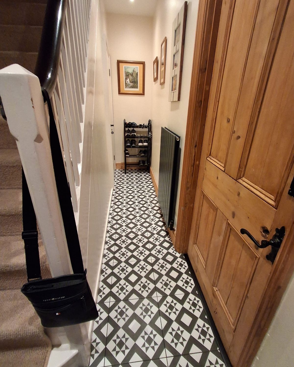 After: the same hallway repainted, with patterned tiles and a new radiator